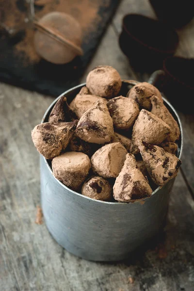 Homemade chocolate truffles in a metal cup on wooden table — Stock fotografie