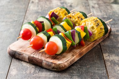 Ahşap masa üzerinde sebze şişleri