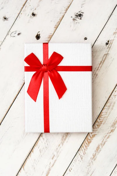 White gift box on white wooden background — Stock Photo, Image