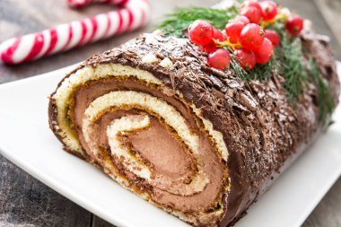 Çikolata yule log Noel Kek ile ahşap background.closeup üzerinde kırmızı kuş üzümü