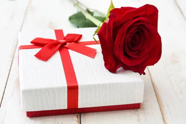Weiße Geschenkschachtel und Rosen auf weißem Holztisch. — Stockfoto