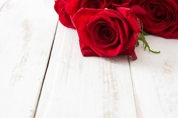 白い木製の background.copyspace に赤いバラ — ストック写真