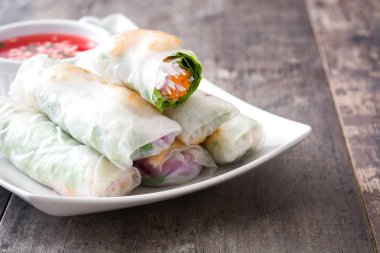 Sebze, pirinç noodle ve ahşap arka plan üzerinde tatlı biber soslu karides ile Vietnam usulü ekmek