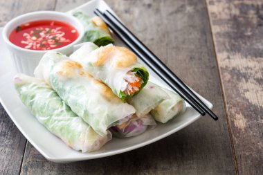 Sebze, pirinç noodle ve ahşap arka plan üzerinde tatlı biber soslu karides ile Vietnam usulü ekmek