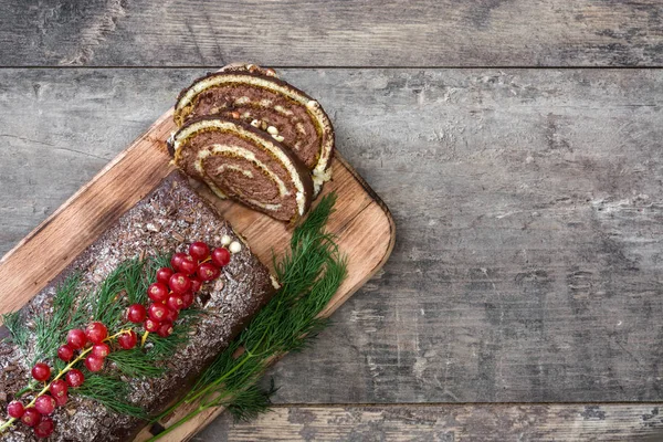 Cioccolato yule log torta di Natale con ribes rosso su sfondo di legno — Foto Stock