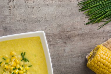 Ahşap arka plan üzerinde beyaz kase mısır çorbası