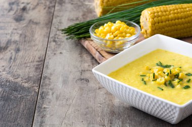 Ahşap arka plan üzerinde beyaz kase mısır çorbası