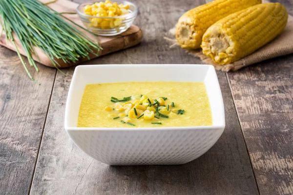 Corn soup in white bowl on wooden background