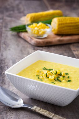 Ahşap arka plan üzerinde beyaz kase mısır çorbası