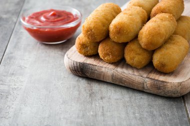 Traditional fried Spanish croquettes with ketchup  clipart