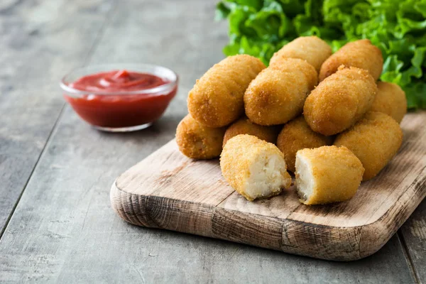 stock image Traditional fried Spanish croquettes with ketchup on wooden background