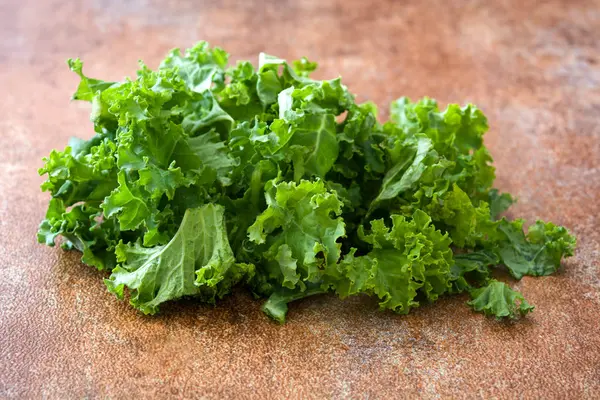 Hojas de col rizada verde fresca sobre fondo rusto — Foto de Stock