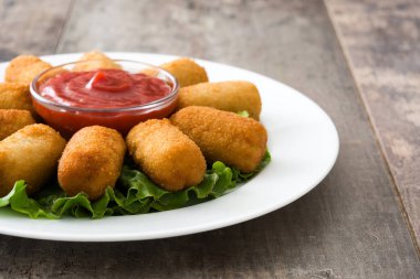Traditional fried Spanish croquetas (croquettes) with ketchup in plate on wooden background clipart