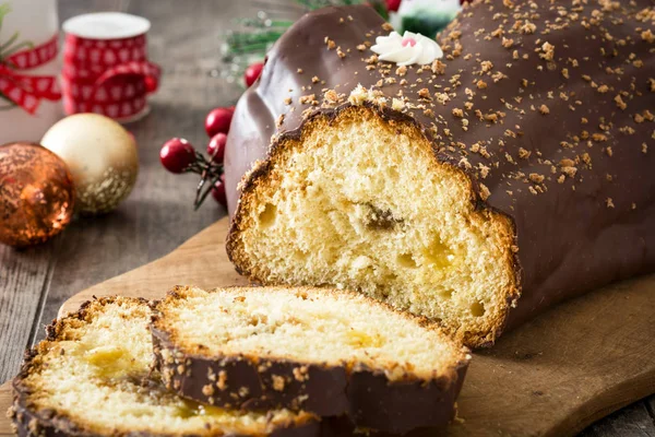 Chocolate yule log pastel de Navidad y adorno de Navidad sobre fondo de madera — Foto de Stock