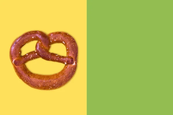 Pretzel on yellow and green background — Stock Photo, Image