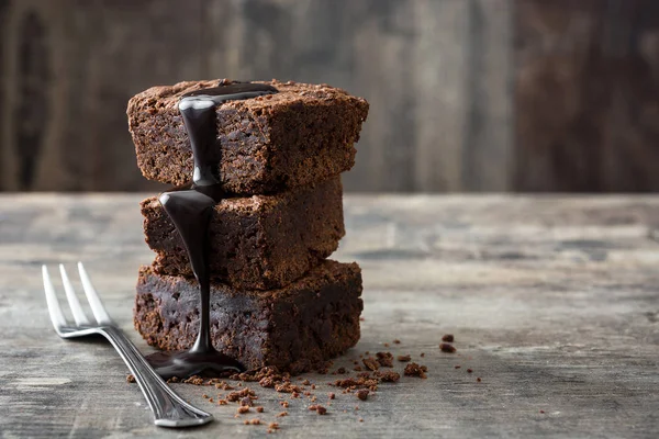 Brownie de chocolate con jarabe de chocolate sobre fondo de madera —  Fotos de Stock
