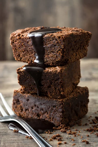 Brownie de chocolate con jarabe de chocolate sobre fondo de madera —  Fotos de Stock