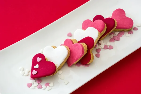 Valentine ciasteczka o kształcie serca na czerwonym tle — Zdjęcie stockowe
