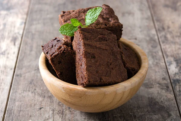 Porzioni di brownie al cioccolato in ciotola su fondo di legno — Foto Stock