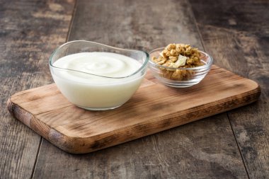 Ahşap masa üzerinde cam kapta Yunan yoğurt