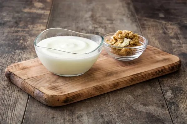 Ahşap masa üzerinde cam kapta Yunan yoğurt