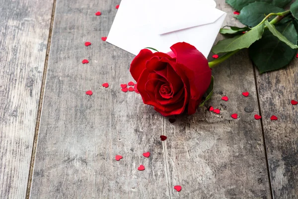 Rosa, sobre y corazones sobre fondo de madera —  Fotos de Stock