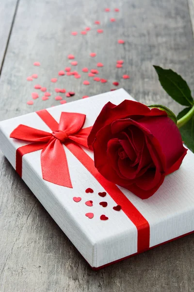 Cutie cadou și trandafir roșu pe fundal din lemn.Conceptul Valentines — Fotografie, imagine de stoc