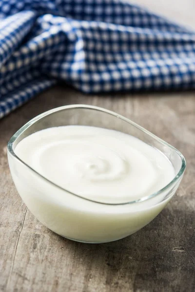 Griekse yoghurt in een glazen kom op houten tafel — Stockfoto