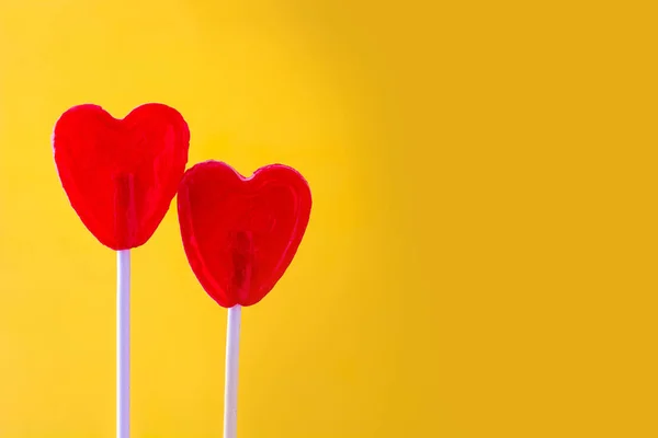 ハート型黄色の背景に赤のロリポップ。愛の概念。バレンタインの日. — ストック写真
