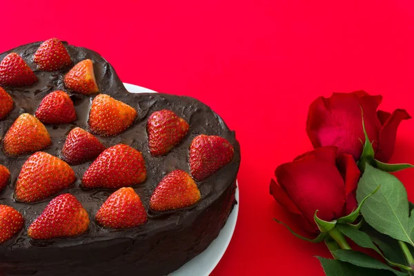 Торт в форме сердца и красные розы на День Святого Валентина или День матери на красном фоне — стоковое фото