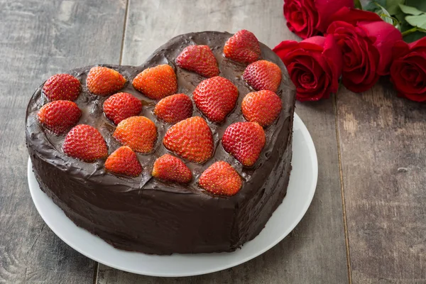 Herzförmige Torte und rote Rosen zum Valentinstag oder Muttertag auf Holzgrund — Stockfoto