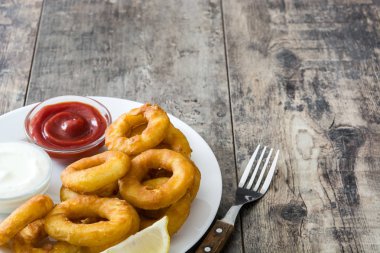 Ahşap zemin üzerine ketçap ile kızarmış kalamar halkaları