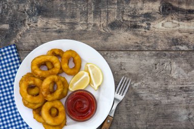 Ahşap zemin üzerine ketçap ile kızarmış kalamar halkaları