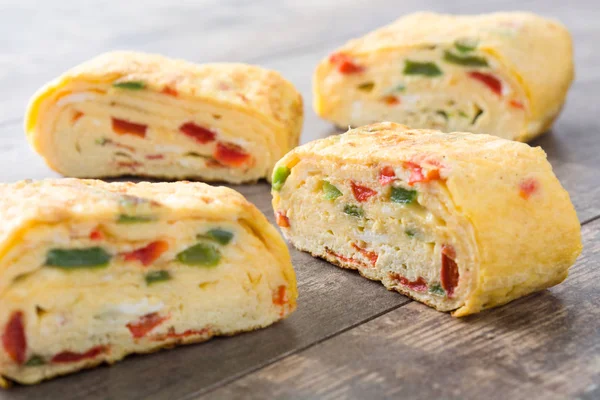 Ahşap arka plan üzerinde geleneksel tamagoyaki Japon omlet
