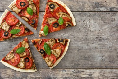 Vejetaryen pizza dilim patlıcan, domates, Siyah Zeytin, kekik ve fesleğen ahşap arka plan ile. Üstten Görünüm