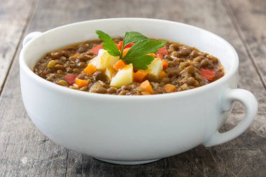 Ahşap arka plan üzerinde bir kasede mercimek çorbası