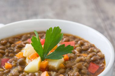 Ahşap arka plan üzerinde bir kasede mercimek çorbası