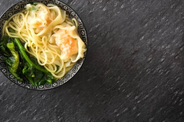 Mantı çorbası siyah kayrak bir kase içinde. Çin yemeği