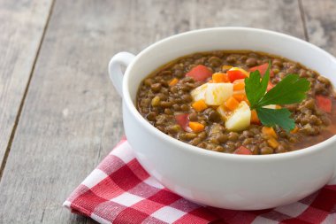Ahşap arka plan üzerinde bir kasede mercimek çorbası