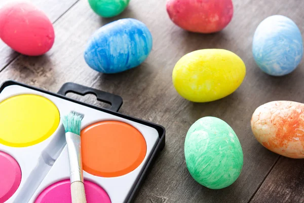 Pintura ovos de Páscoa coloridos em fundo de madeira — Fotografia de Stock