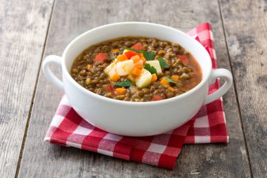 Ahşap arka plan üzerinde bir kasede mercimek çorbası