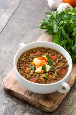 Ahşap arka plan üzerinde bir kasede mercimek çorbası