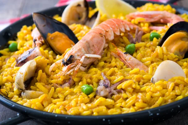 Paella tradicional española de mariscos sobre fondo de madera — Foto de Stock