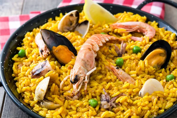 Traditional spanish seafood paella on wooden background
