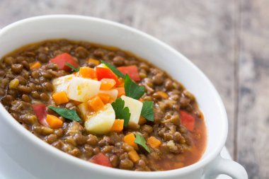 Ahşap arka plan üzerinde bir kasede mercimek çorbası