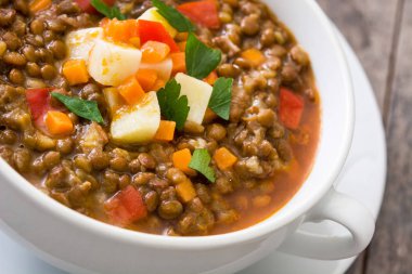 Ahşap arka plan üzerinde bir kasede mercimek çorbası