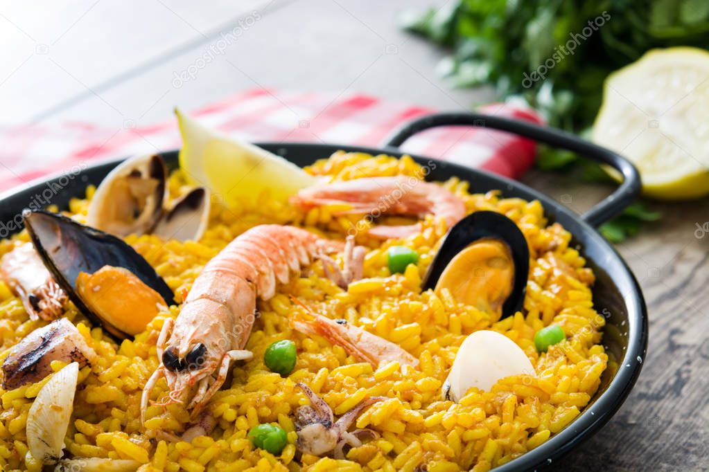 Traditional spanish seafood paella on wooden background