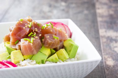 Avokado, turp ve susam ahşap arka plan üzerinde kase Hawaiian tuna poke