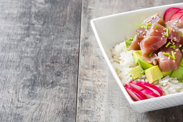 Hawaiian tuna poke bowl with avocado, radishes and sesame seeds on wooden background — Stock Photo, Image