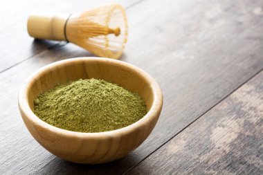 Ahşap arka plan üzerine bir kase ve bambu çırpma teli Matcha yeşil çay